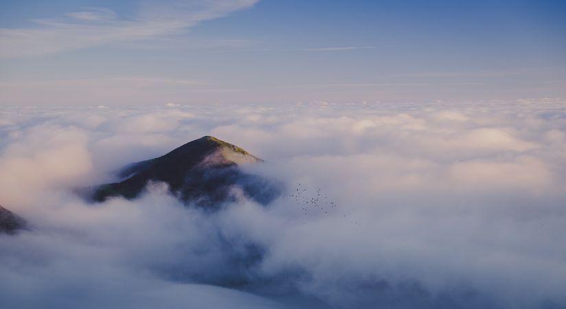Wonderful view of blue sky above thick clouds in valley from mountain