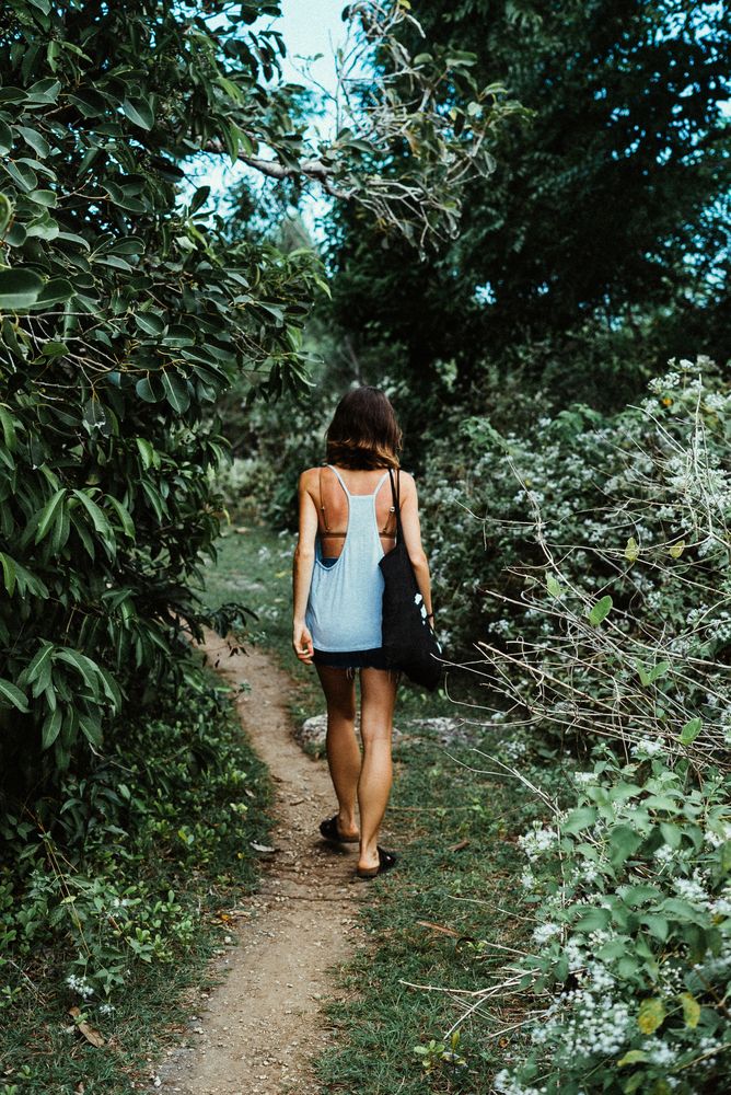 Back of woman walking into forest