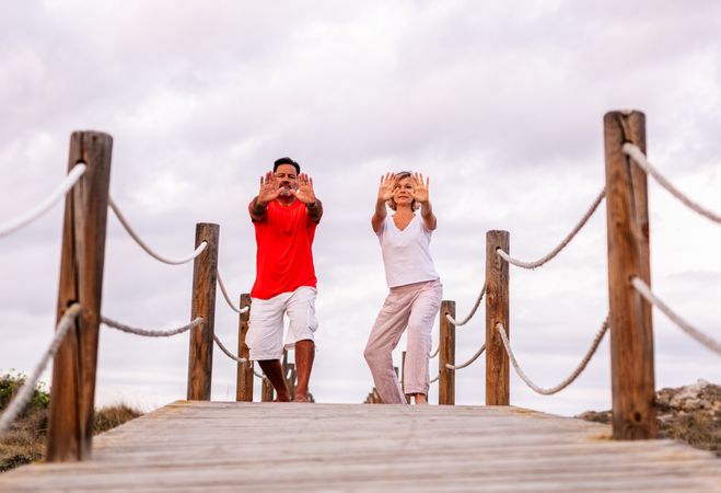 Couple practicing martial arts on lumber path