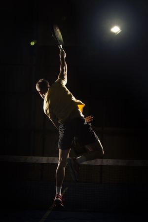 Man playing padel in darkness