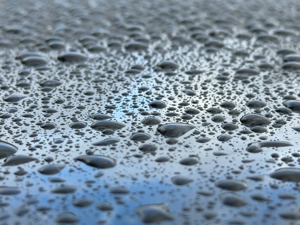 A wet surface with many small drops of water scattered across it