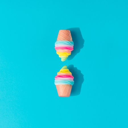 Two colorful ice cream cones on bright blue background