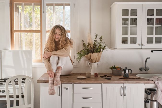 Young woman sitting in kitchen