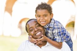 Father and Son Playing Piggyback in Sunny Park