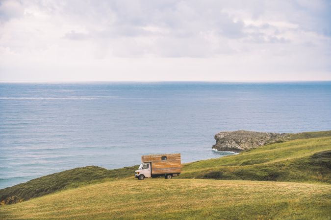 Landscape of empty meadow with passing truck near seaside