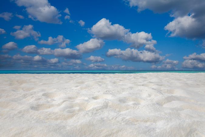 Light sand with tropical blue waters in the distance
