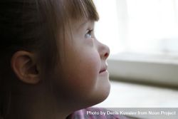 Close up portrait of little girl with Down syndrome looking out a window 4ApXQ5