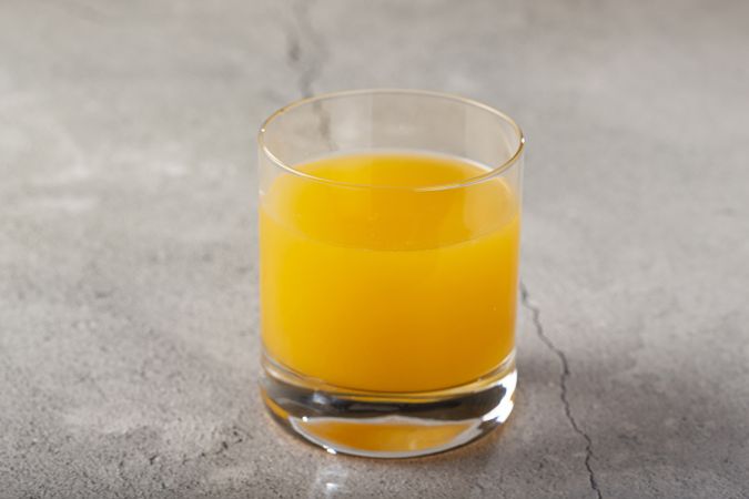 Glass with orange juice on the table.