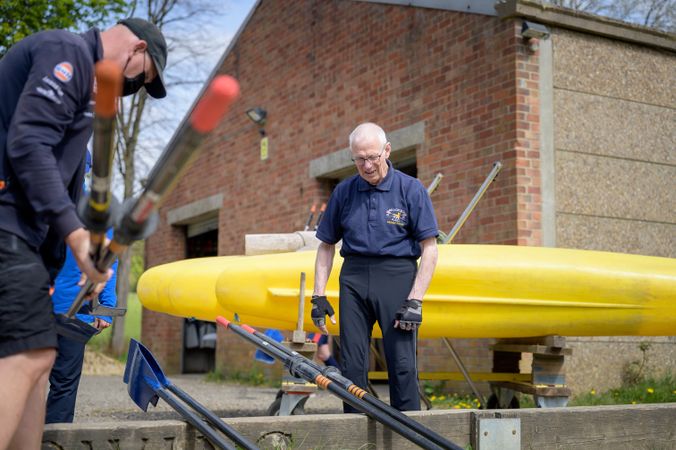Older men preparing oars before rowing