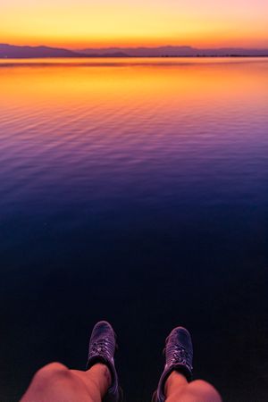 Anonymous traveler near sea on sunset