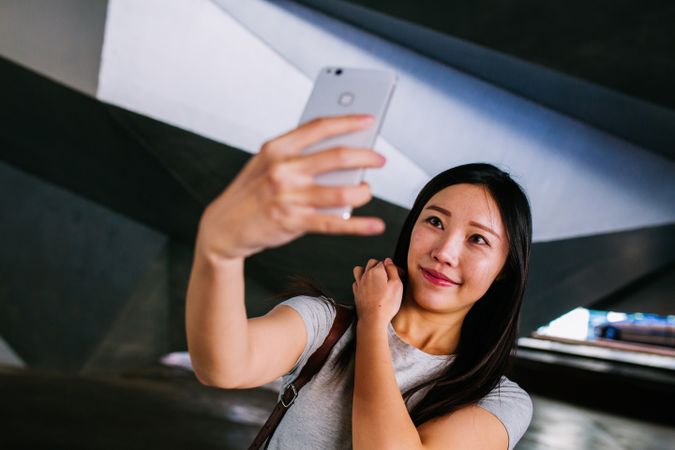 Asian female taking selfie in underground passage