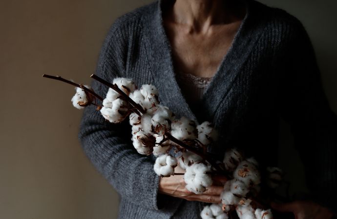Crop woman with cotton twigs