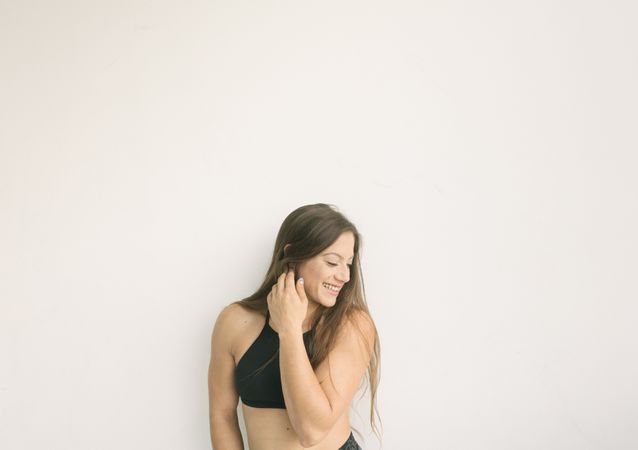 Young sportive woman near wall