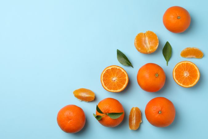 Ripe sweet mandarins on blue background, top view