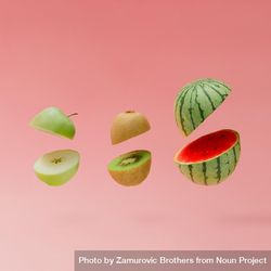 Watermelon, apple and kiwi halved on pastel pink background 4OWn74