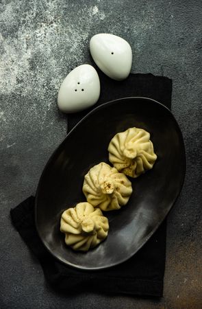 Top view of plate of three Georgian khinkali dumplings