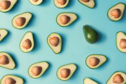 Avocado halves pattern on a pastel blue background
