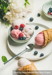 Scoops of ice cream in bowl and in waffle cones with berries 5zNRj5