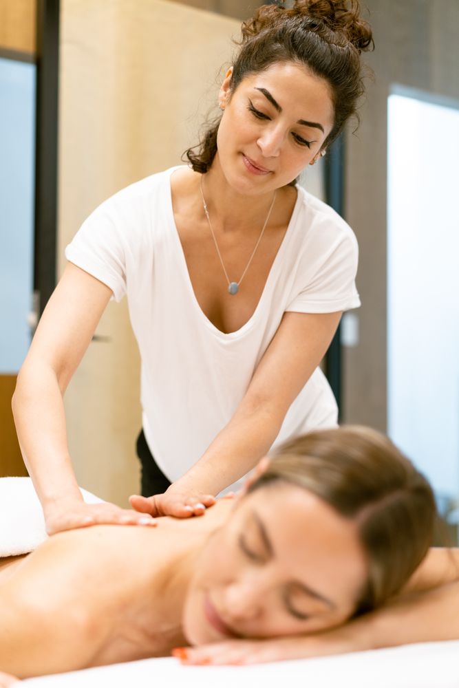 Woman receiving a relaxing massage at the spa by a professional masseuse