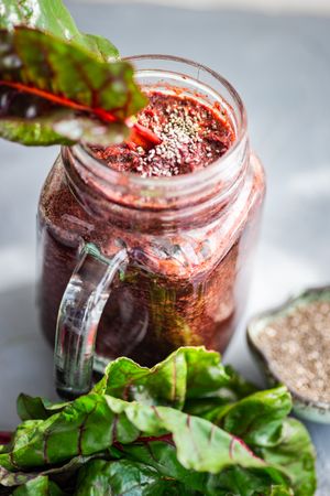 Beet smoothie in mason jar with chia seeds with greens