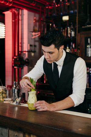 Barman working preparing drink in a glass