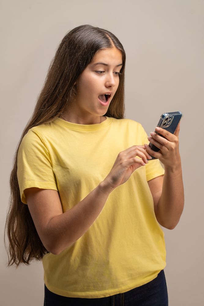 Shocked young woman reacting to unbelievable content on her smartphone.