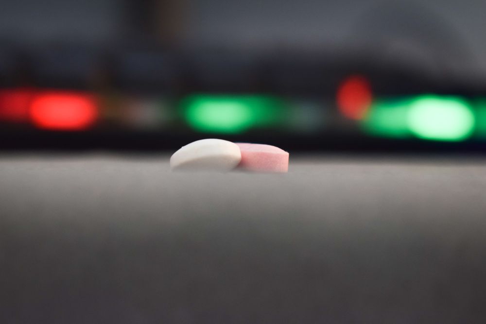 Two loose pills with bokeh in background