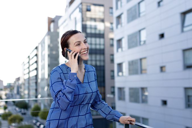 Serious manager speaking on phone on street