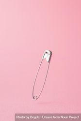 Close up of one safety pin on pink background 5rENp0