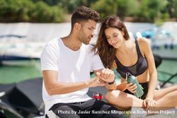Male and female talking together on pier after exercising 0yeqn0