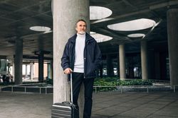 Stylish mature tourist standing outdoors waiting on taxi