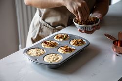 Faceless person cooking muffins with walnuts