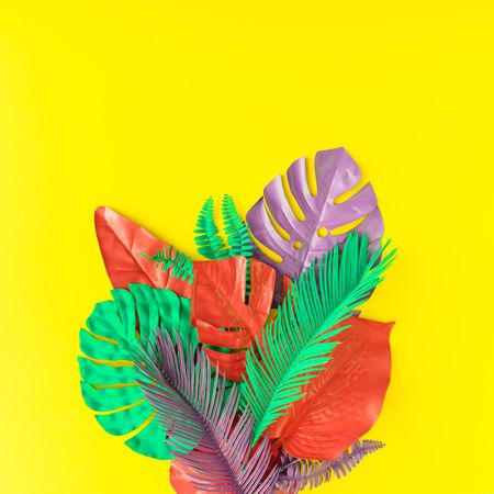 Painted tropical and palm leaves in vibrant bold colors on yellow background