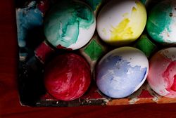 Set of painted Easter eggs in container on table