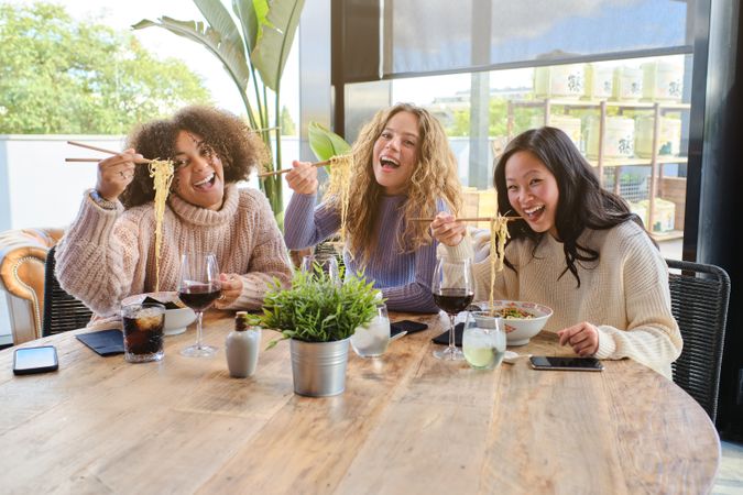 Delightful diverse female friends enjoying lunch in restaurant