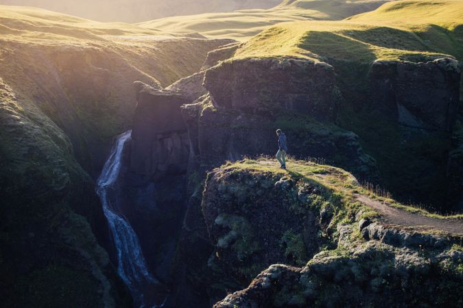 Man walking towards edge of cliff