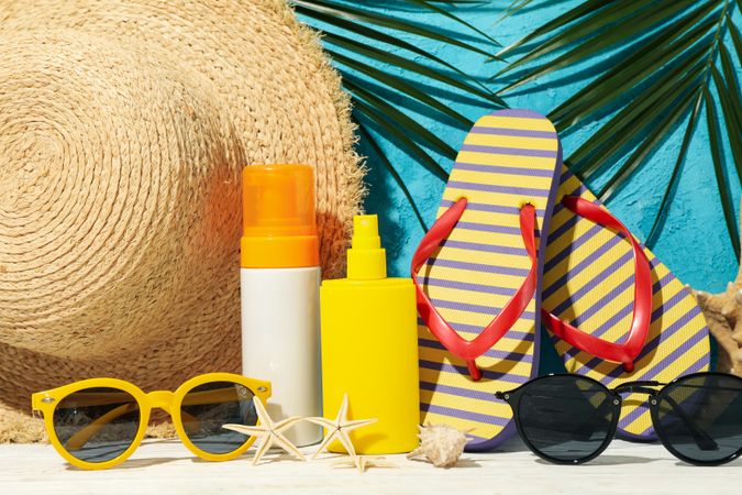 Summer vacation accessories against blue background, close up