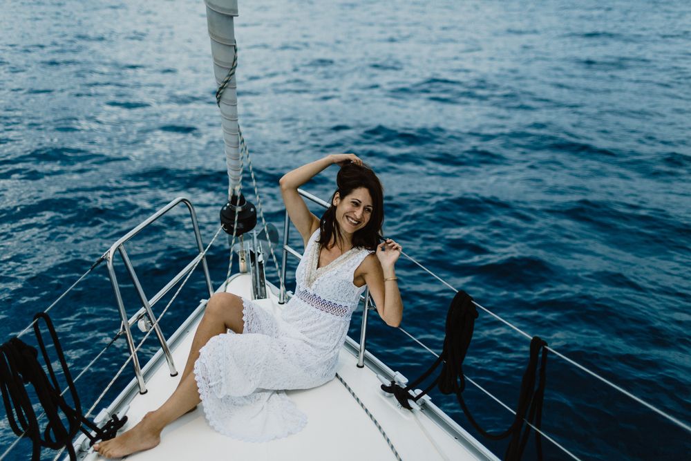 Barefoot bride resting on yacht bow