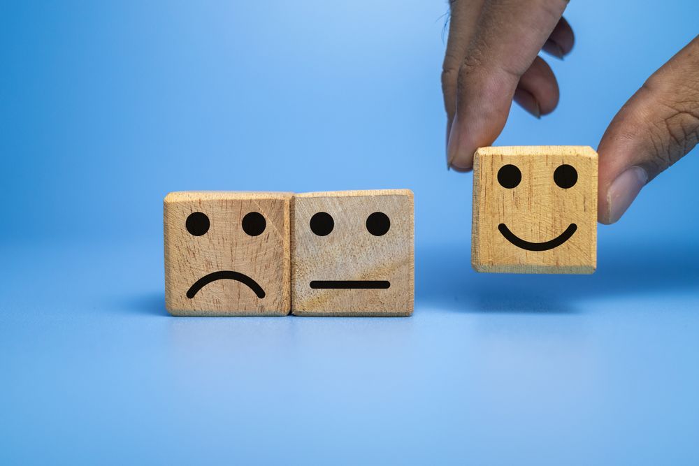 sad, flat and happy face expression emoticon on wooden cubes