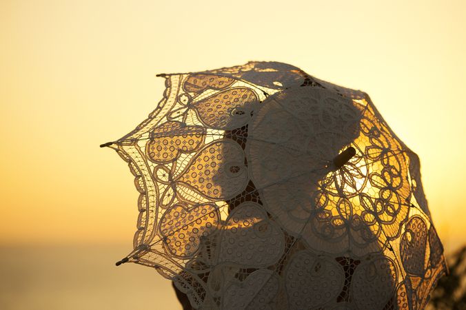 Woman with vintage umbrella at sunset