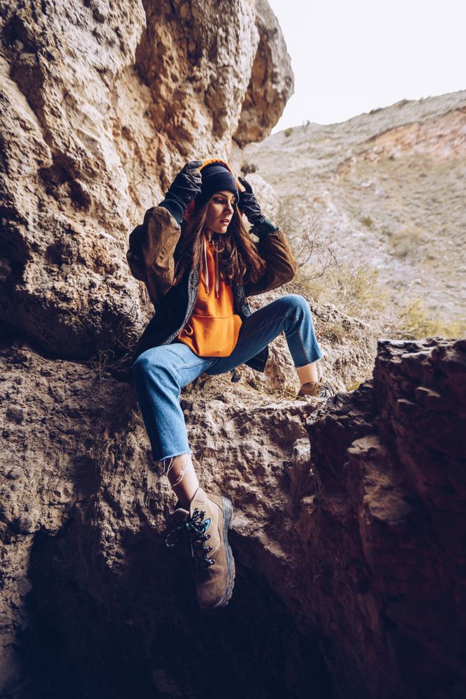 Neutral female hiker resting in rocky slope