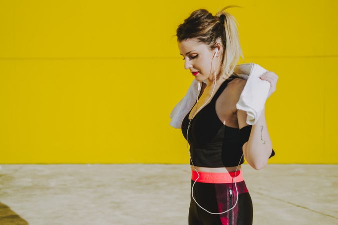 Woman cleaning with sweat towel on yellow background