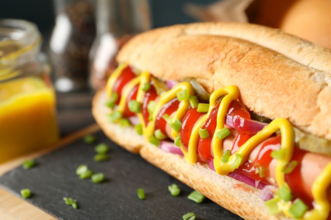 Tasty hot dog on cutting board, close up