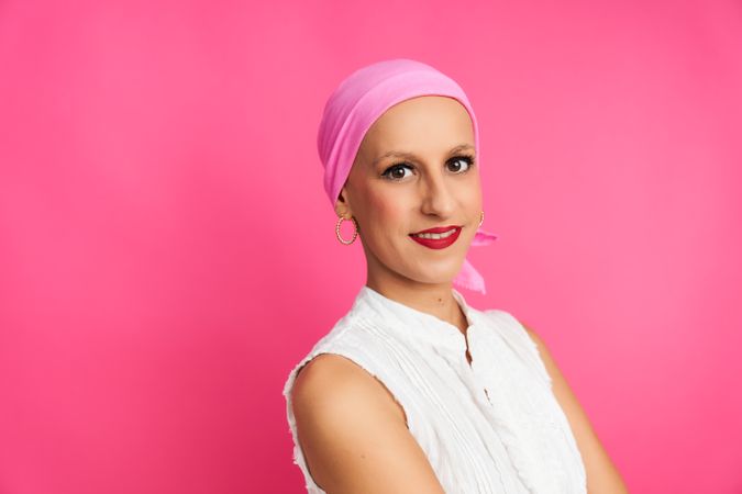 portrait of optimistic woman suffering from cancer with pink head scarf