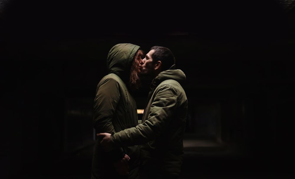 A couple's kiss in the darkness.