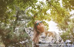 Woman with sunglasses touching over nature background 0Pjkdm