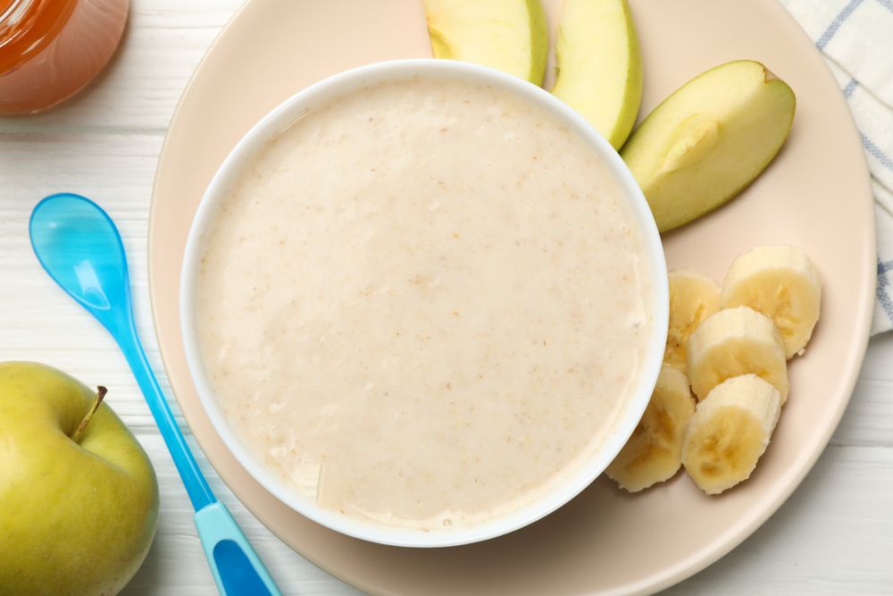 Composition with baby food on plain wooden background