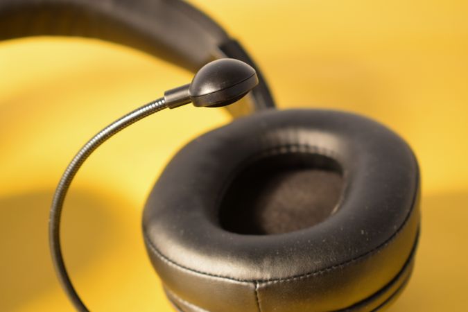 Single headphone ear speaker on yellow table