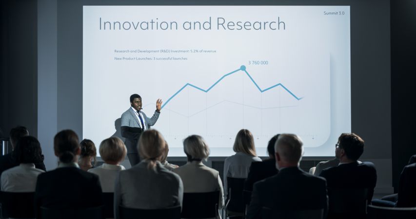 Corporate Event: Black Male Tech CEO Giving Presentation To Colleagues or Investors In the Conference Room Of Innovative Startup Office.