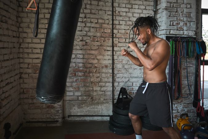 Black guy boxing in gym